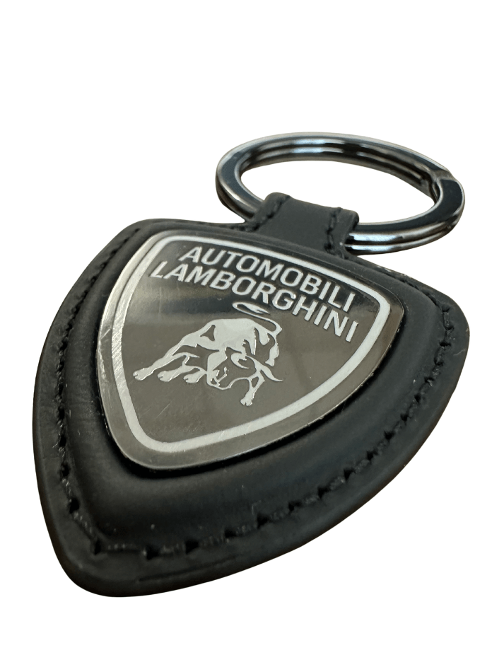 Portachiavi Automobili Lamborghini in pelle con logo distintivo su sfondo nero.